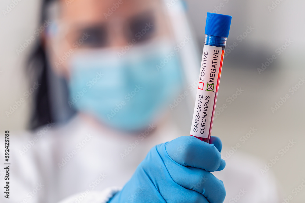 Female medic holds a negative coronavirus test in her hand