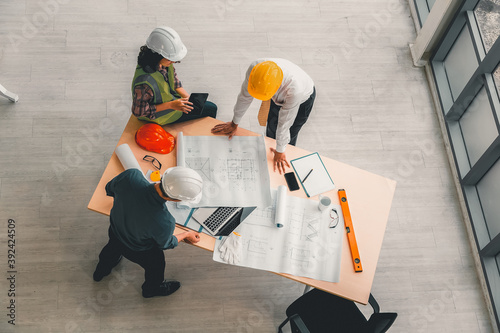 Team of engineers and architects working, planing, measuring layout of building blueprints in construction site. top view