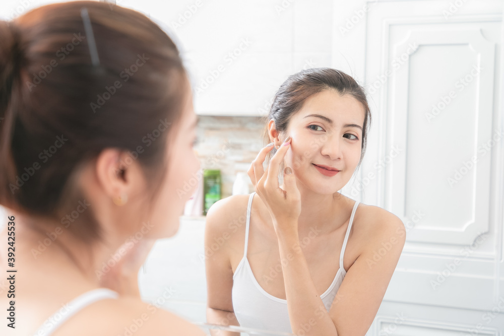 Asian Beauty Woman apply face cream in bathroom. Asian Beauty Woman apply face cream in bathroom.