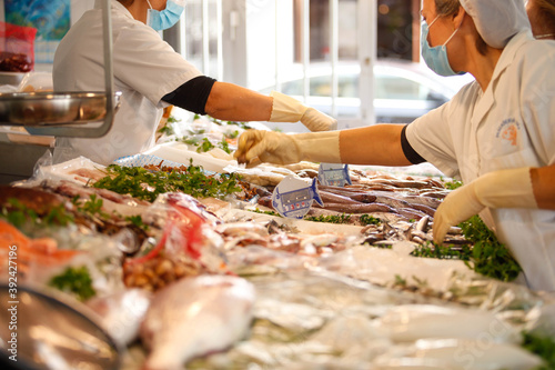 Working portrait of a fishmonger with workers photo