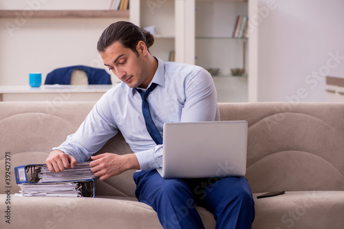 Young male employee working from home in pandemic concept