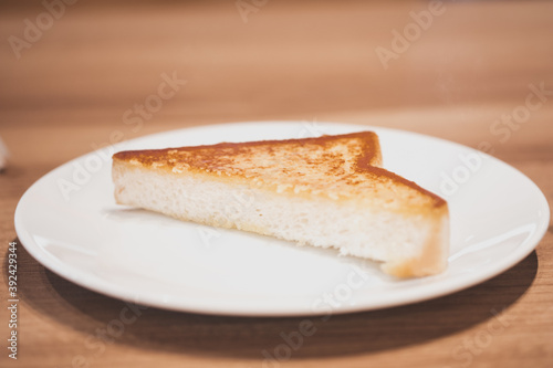 Triangle of garlic bread on white dish