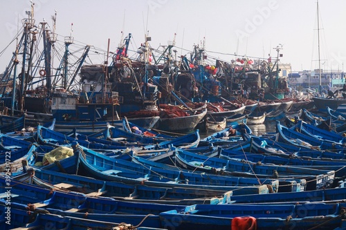 ESSAOUIRA, MOROCCO - SEPTEMBER 29. 2011: Countless blue fishing boats squeezed together in an utterly cramped harbor photo