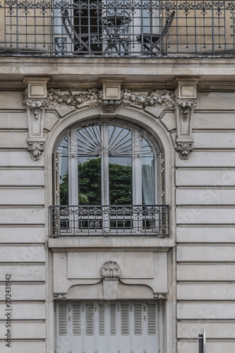 Old French house with traditional balconies and windows. Paris, France.