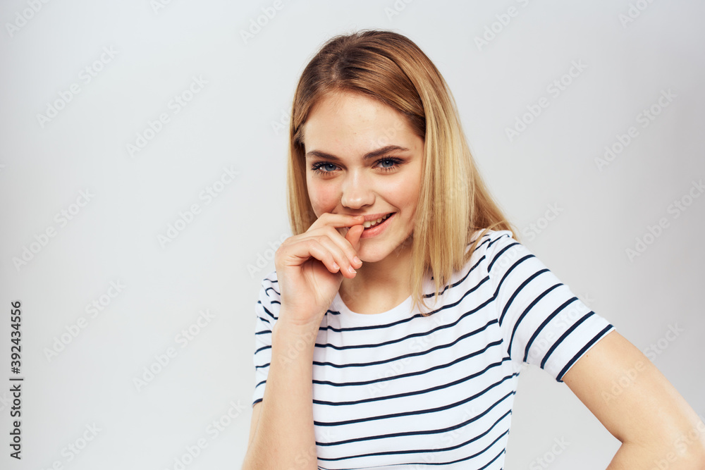 emotional woman in striped t-shirt gesture with hands lifestyle light background emotional woman in striped t-shirt gesture with hands lifestyle light background