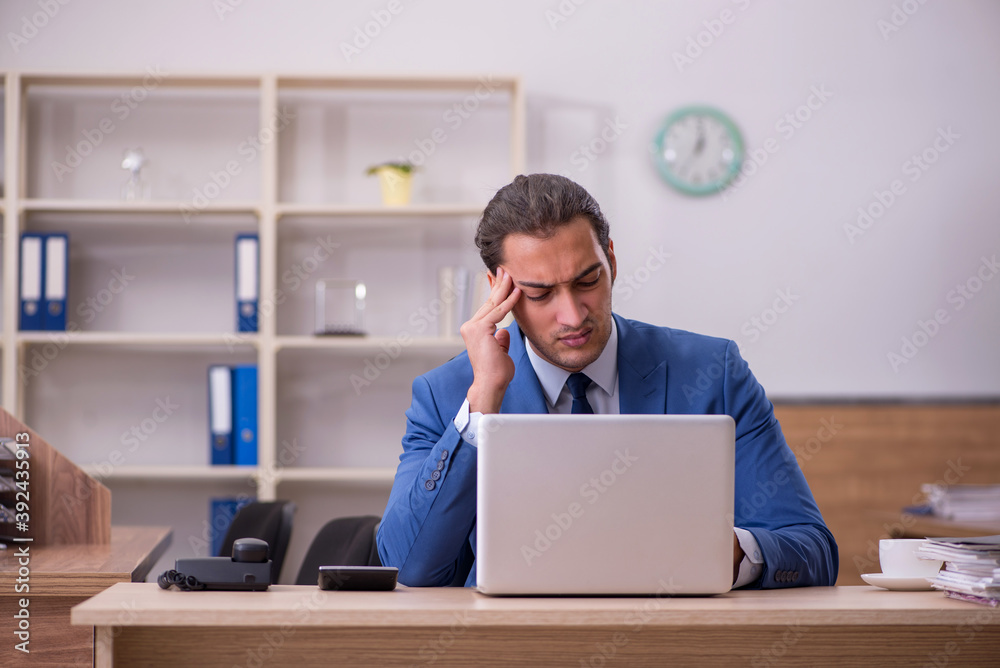 Young sick businessman employee suffering at workplace