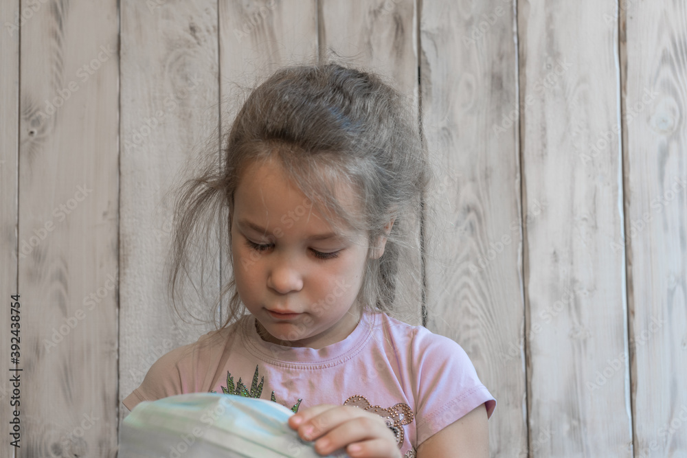 Fototapeta premium A small girl with a medical mask