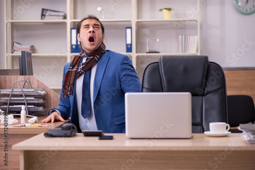 Young sick businessman employee suffering at workplace
