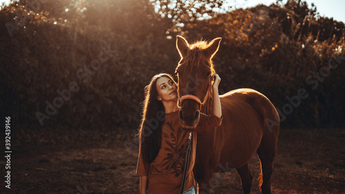 Chica joven andaluza ecuestre montando sobre caballo marron en un campo natural sin silla ni riendas en el sur de españa al atardecer feliz © Tony Moguer