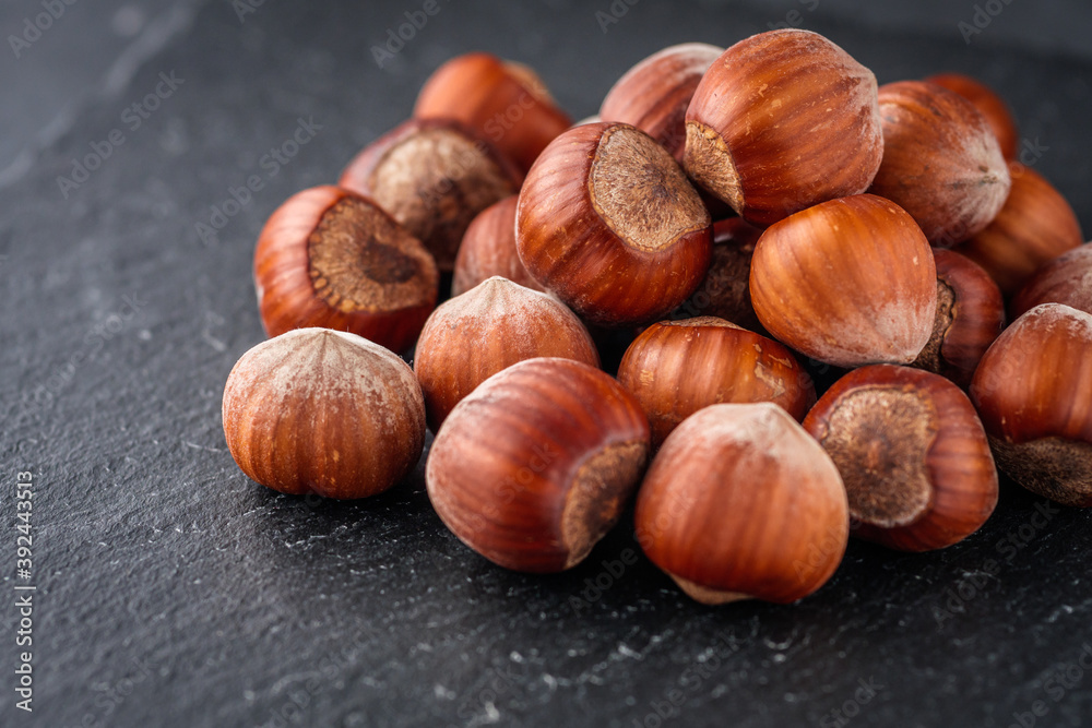 fresh natural hazelnuts on a dark stone background fresh natural hazelnuts on a dark stone background