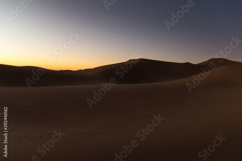 Dreamy desert concept at Twilight of dawn at desert dune of Erg Chigaga, at the gates of the Sahara. Morocco. Concept of travel and adventure