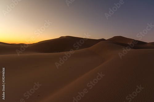 Dreamy desert concept at Twilight of dawn at desert dune of Erg Chigaga, at the gates of the Sahara. Morocco. Concept of travel and adventure