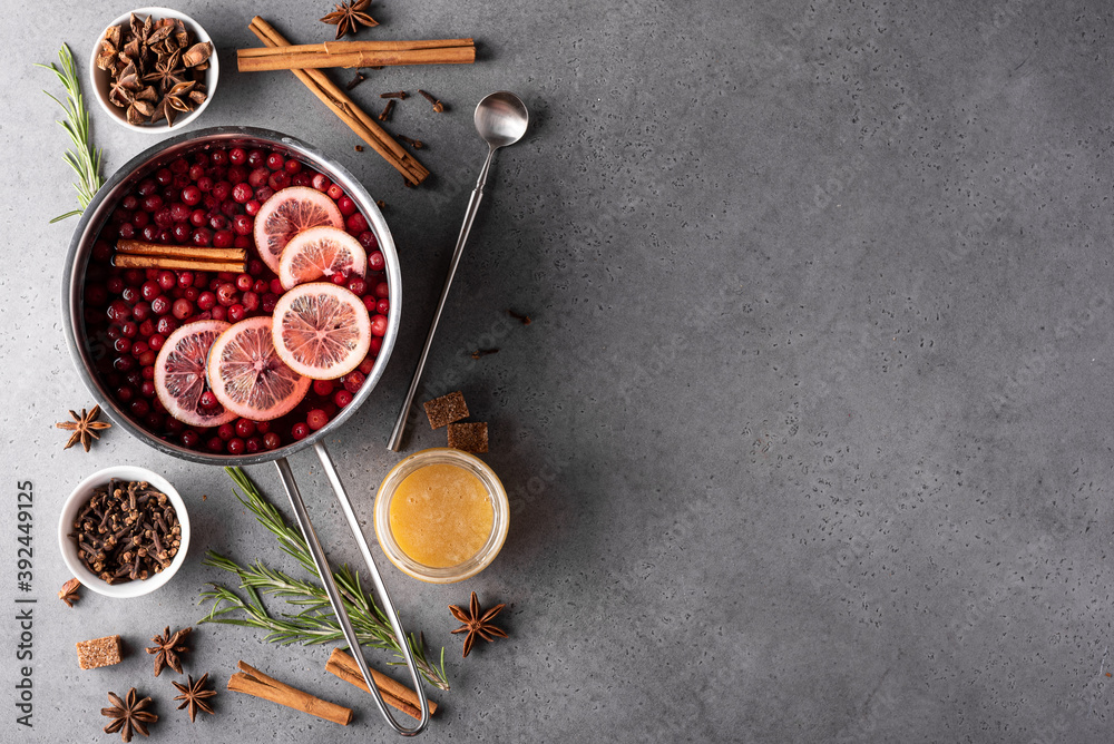 hot cranberry drink with lemon honey and spices in a gray saucepan