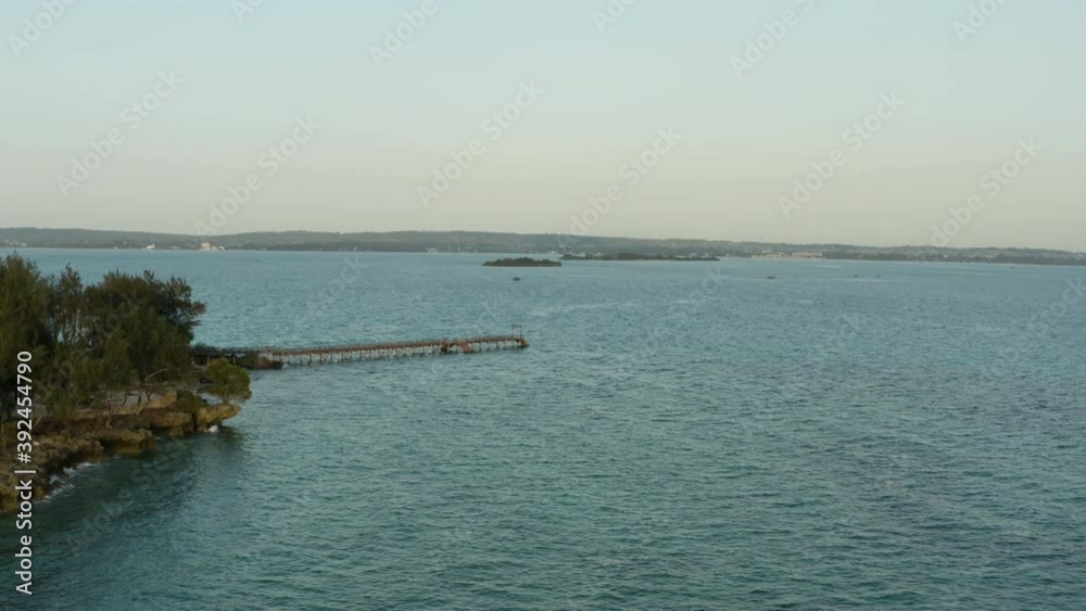 Aerial shot Zanzibar Tanzania. Drone flight over a wooden pier on an island with trees and rocks, a beautiful landscape in the Indian Ocean with blue water. Prison Island.
Aerial shot Zanzibar Tanzania. Drone flight over a wooden pier on an island with trees and rocks, a beautiful landscape in the Indian Ocean with blue water. Prison Island.