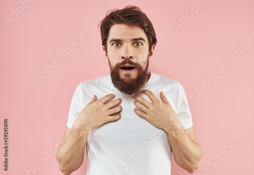 Surprised man holding hand near face emotions pink background cropped view