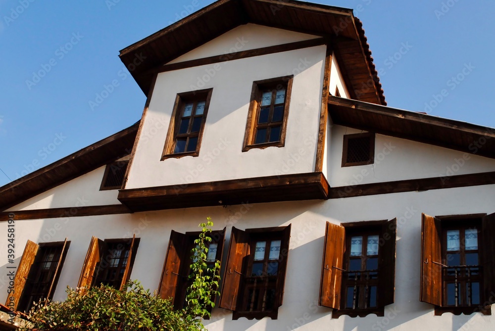 Low angle of traditional ottoman house windows against blue sky in Safranbolu, Turkey. UNESCO world heritage site. 