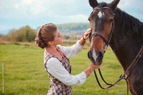 Beautiful elegant female rider next to the horse's muzzle. People and animals. Rider.