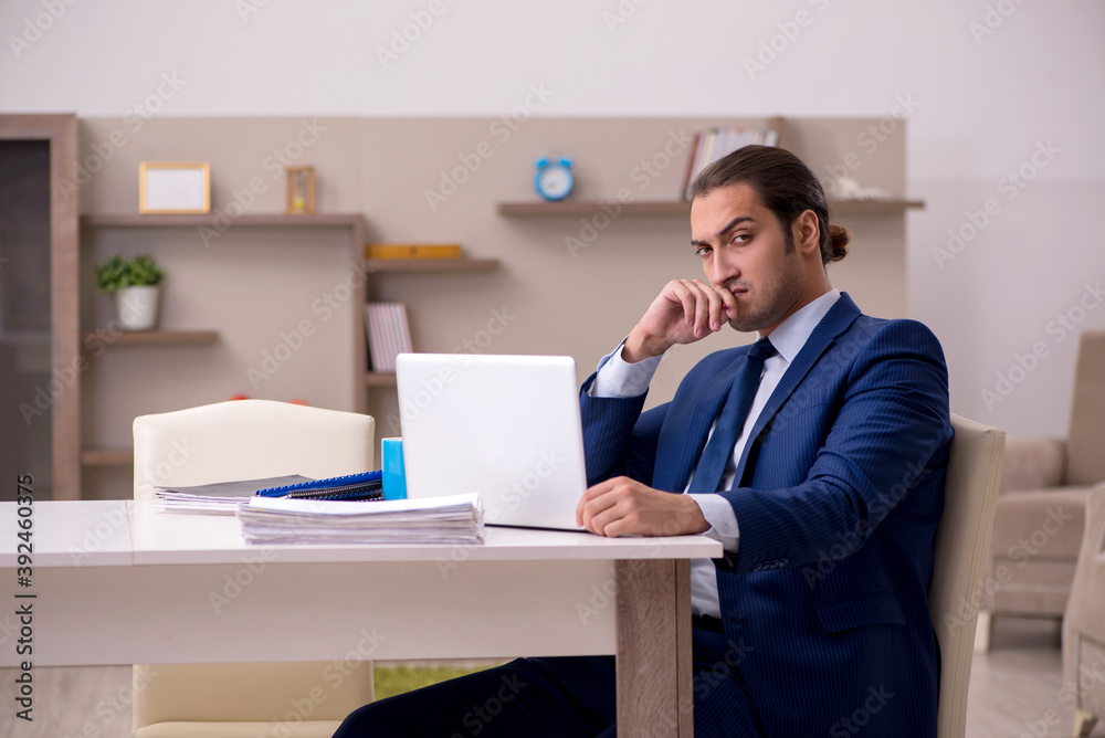 Young male employee working from home in pandemic concept