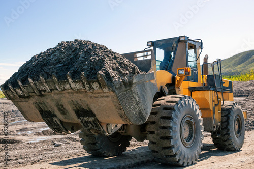 Wheel loader at work. It transports gold-bearing mountain soil to the hopper of the washing device. The gold mining industry in Eastern Siberia widely uses such equipment as front loader, bulldozer, 