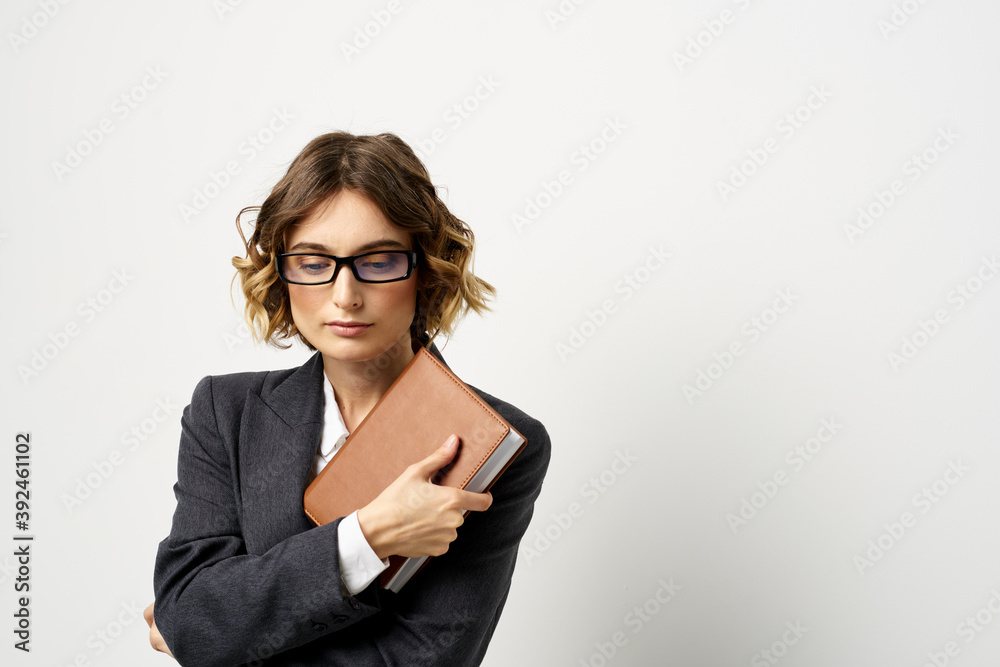 Woman at work with book in hand light background classic suit glasses head Woman at work with book in hand light background classic suit glasses head