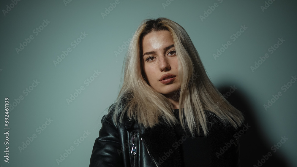 Young blonde charming attractive pretty blonde hair woman looking at camera in office or at home, dressed in blond black Young blonde charming attractive pretty blonde hair woman looking at camera in office or at home, dressed in blond black
