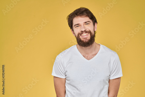 Bearded man on emotions white t-shirt fun lifestyle yellow background