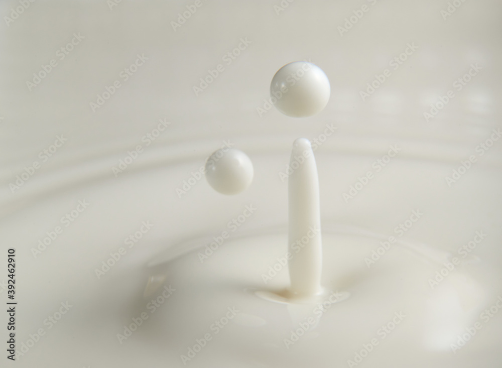 A drop of milk falls down. Abstract blue red background.