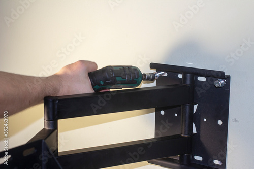 Fotografija Tightening the bolt by a Cordless Electric Screwdriver