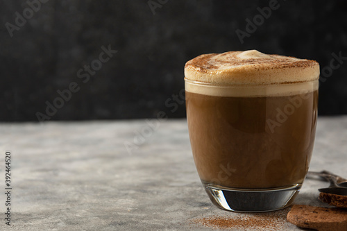 Vászonkép Glass of coffee drink with whipped milk, dark background.