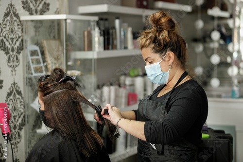 Woman with face mask getting a fresh style at a hair salon. Woman getting a hair wash. Hairdressing concept.