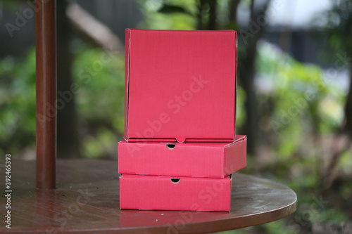 3 red boxes stand on the table. mock up box design