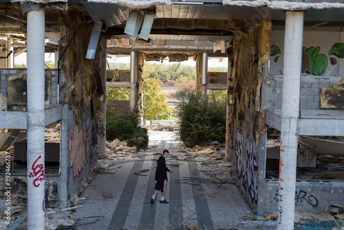 homme avec un visage étrange marchant dans un grand bâtiment détruit et abandonné 