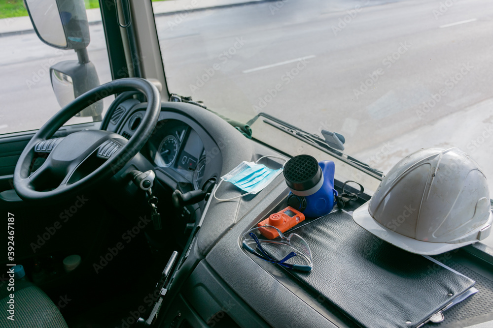 Personal protective equipment in the cabin of a truck that transports dangerous goods, consisting of a helmet, protective glasses, gas mask and an explosimeter.