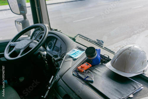 Personal protective equipment in the cabin of a truck that transports dangerous goods, consisting of a helmet, protective glasses, gas mask and an explosimeter. © M. Perfectti
