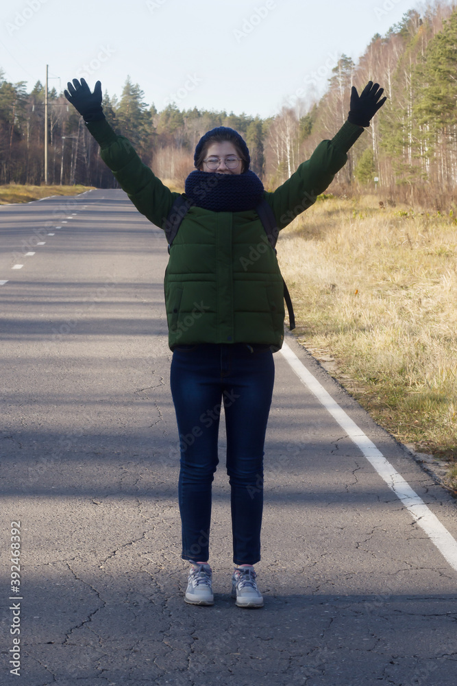Fototapeta premium the tourist girl put her hands up on the road