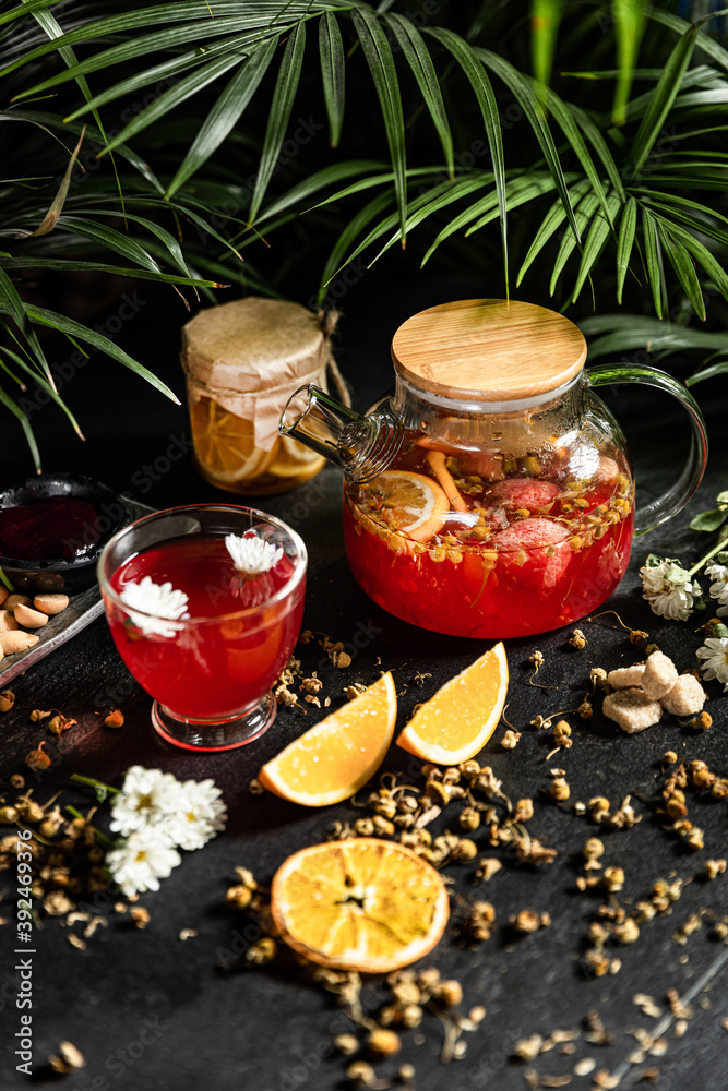 Fruit hot tea with the addition of oranges, lemons, mandarins and raspberries in a glass cups on a table. Healthy hot drink. tea with fruit and berries in a glass teapot. tea for colds.