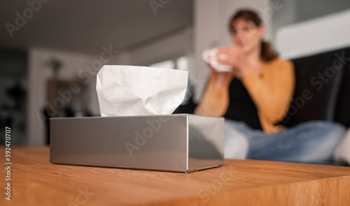 Quadro su tela Focus of a stainless steal dispenser with paper handkerchiefs and a young woman