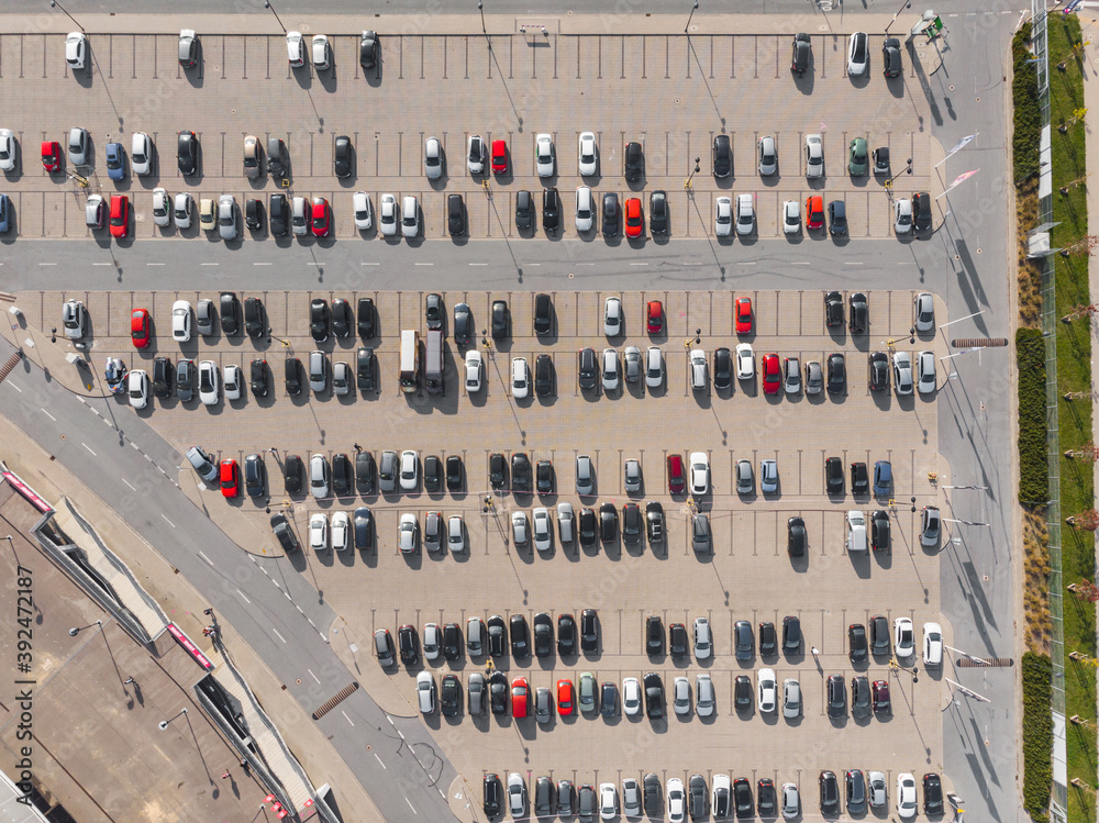 Aerial top down view to parking full of cars with isolated red cars