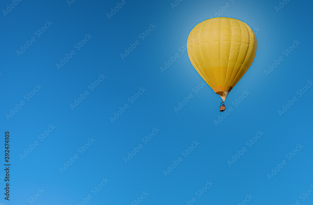 Obraz premium A lone balloon rises high in the blue sky