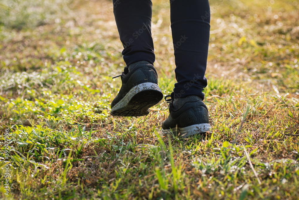 Senior woman jogger jogging in the morning in nature trail, close-up shot on legs and dirty shoes. Senior woman jogger jogging in the morning in nature trail, close-up shot on legs and dirty shoes.