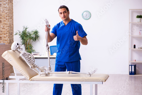 Young male doctor and skeleton on the couch