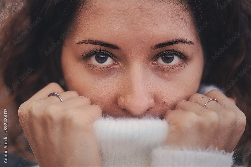 Portrait of a woman pulling her white sweater over head