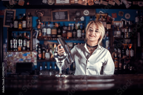 Girl barman creates a cocktail in the brasserie