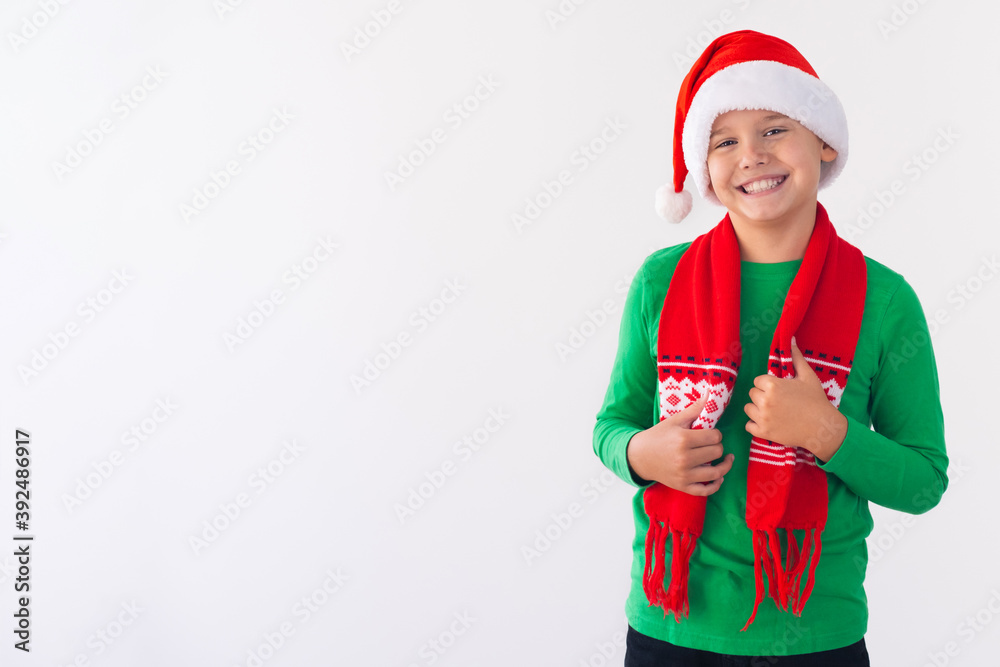Portrait of happy boy wearing Santa Claus hat and winter scarf. Merry Christmas time. Portrait of happy boy wearing Santa Claus hat and winter scarf. Merry Christmas time.