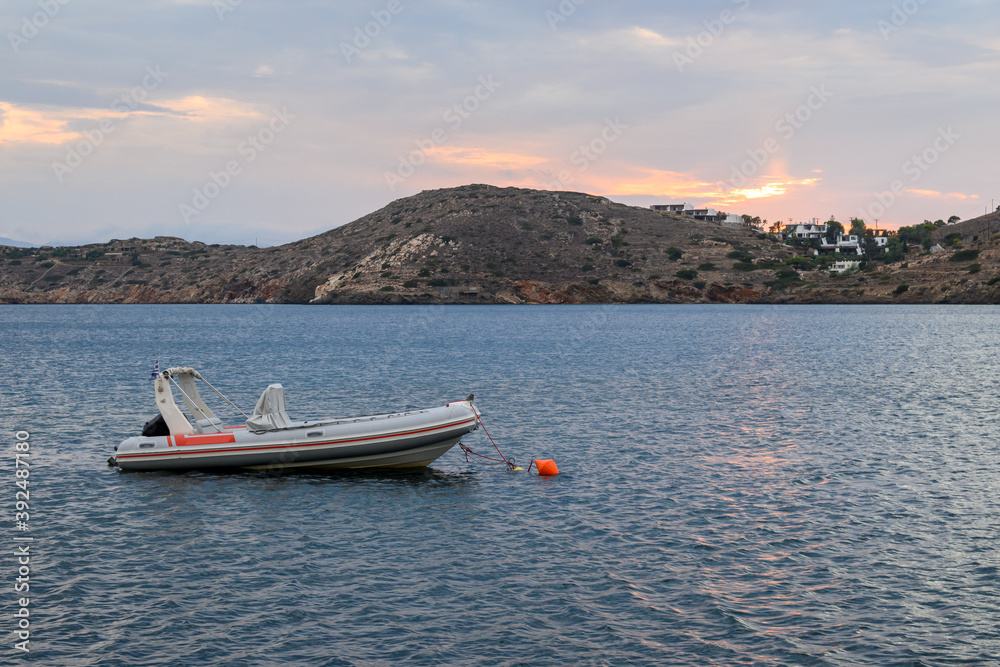 A boat moored in the bay during evening on Ios Island. Cyclades, Greece