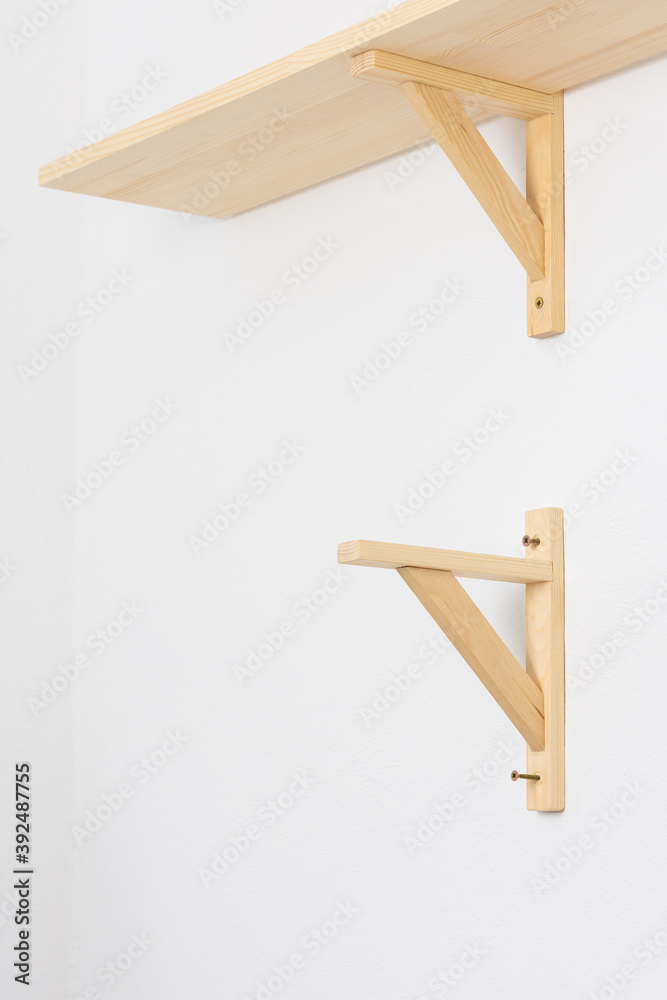 The process of attaching a wooden shelf to the wall, shelf corners The process of attaching a wooden shelf to the wall, shelf corners