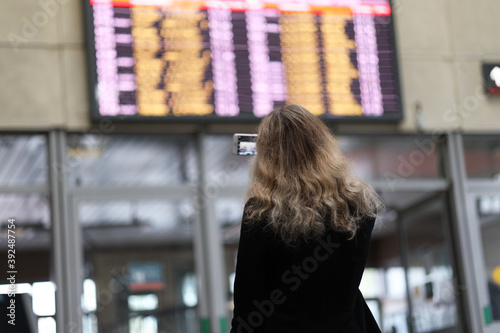 the girl watches the schedule of trains or planes