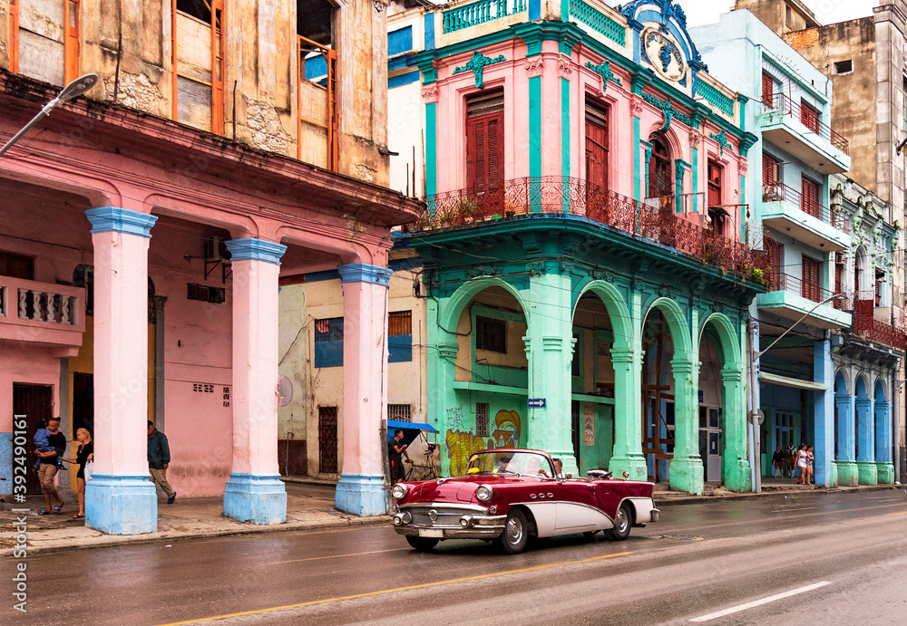 convertible classic car in front of colorful houses in havana cuba - obrazy, fototapety, plakaty 