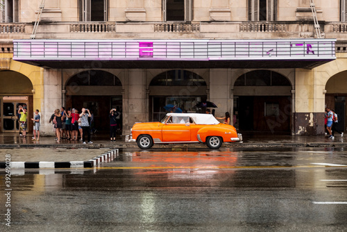 old orange and white classic car in front of vintage building in havana cuba © Michael Barkmann