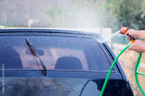  water from a hose with a sprayer washes the car